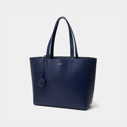 The diagonal view of the navy MOONSHAFT tote bag displayed against a white background. The bag features a sleek, minimalist design with reinforced stitching along the handles, emphasizing its spacious and structured silhouette.