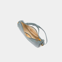 Top view of the Crescent Moon bag in ash blue, showcasing the smooth leather exterior and gold zipper partially open, revealing the beige interior lining. The inside compartment features a simple yet spacious design with a small slip pocket for organization. The elegant contrast between the black leather and light interior is highlighted.