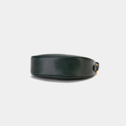 Bottom view of the Crescent Moon bag in pine grove, showcasing the smooth leather base with a minimalistic and sleek finish. The design emphasizes the clean lines and structure of the bag, with subtle stitching details along the edges. The gold hardware complements the elegant black leather, adding a touch of sophistication.