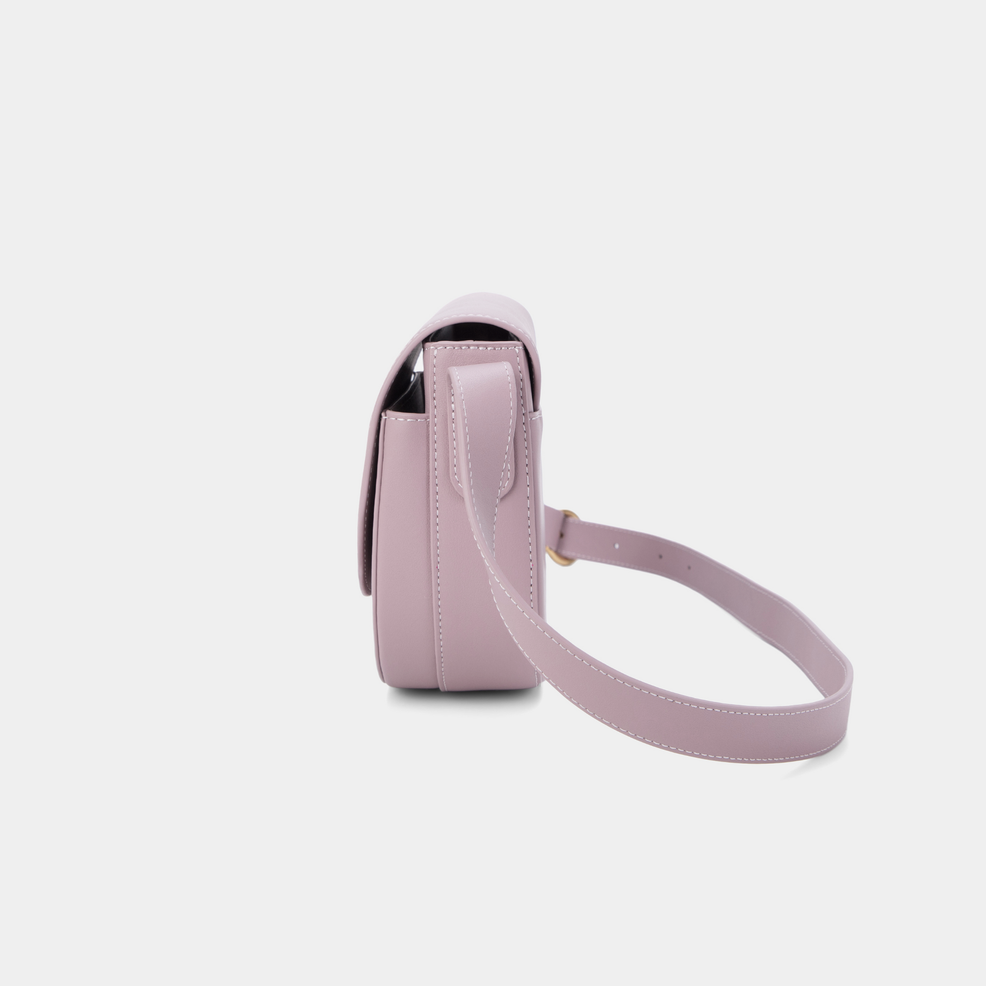 A side view of a light lilac half-moon crossbody bag showcasing its structured profile. The bag has a sleek, smooth leather finish, and its curved base complements the minimalistic design. The adjustable leather strap and gold-tone hardware are visible from this angle, adding a touch of refinement.