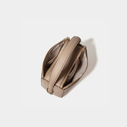 A top view of the Mini Double Zip Bag in sandstone color, displaying its two spacious zippered compartments. The bag, made from pebbled leather, features a light-colored fabric lining for organized storage. The sturdy top handle and gold-tone hardware are visible, enhancing the bag’s functional and elegant design