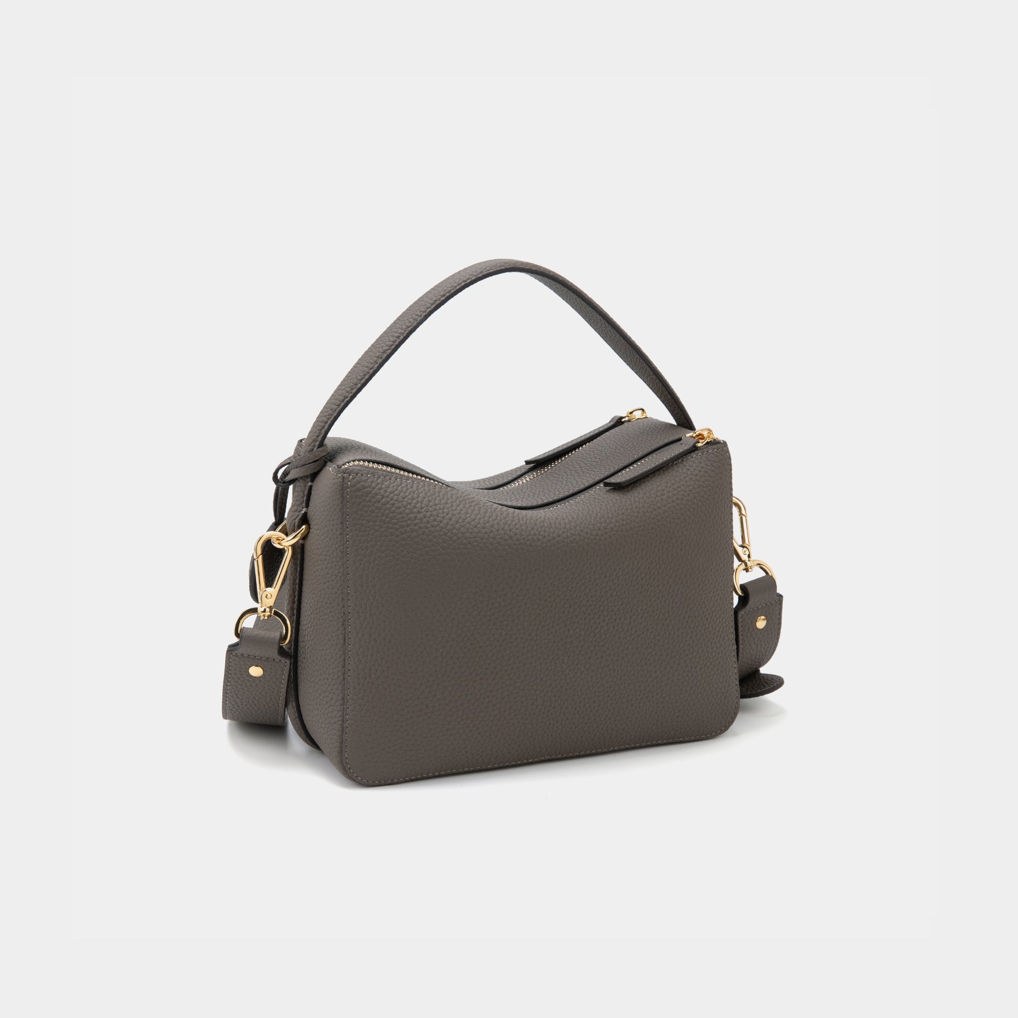 A back view of the upgraded double zip leather bag in charcoal, displayed at a diagonal angle. The pebbled leather texture and structured design are highlighted, with two parallel gold-tone zippers running across the back. The minimalist design and clean lines emphasize the bag’s high-quality craftsmanship.