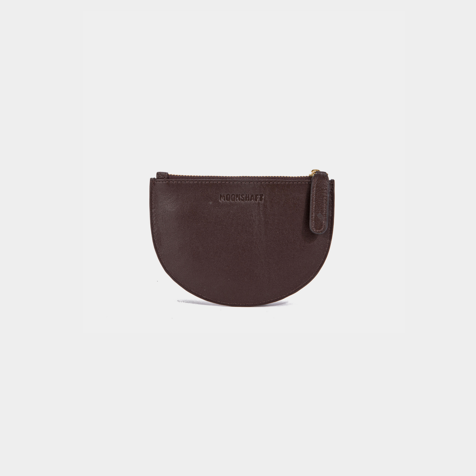 A brown Half Moon Coin Purse made of goat leather with a zipper on the top and an embossed MOONSHAFT logo on the front.