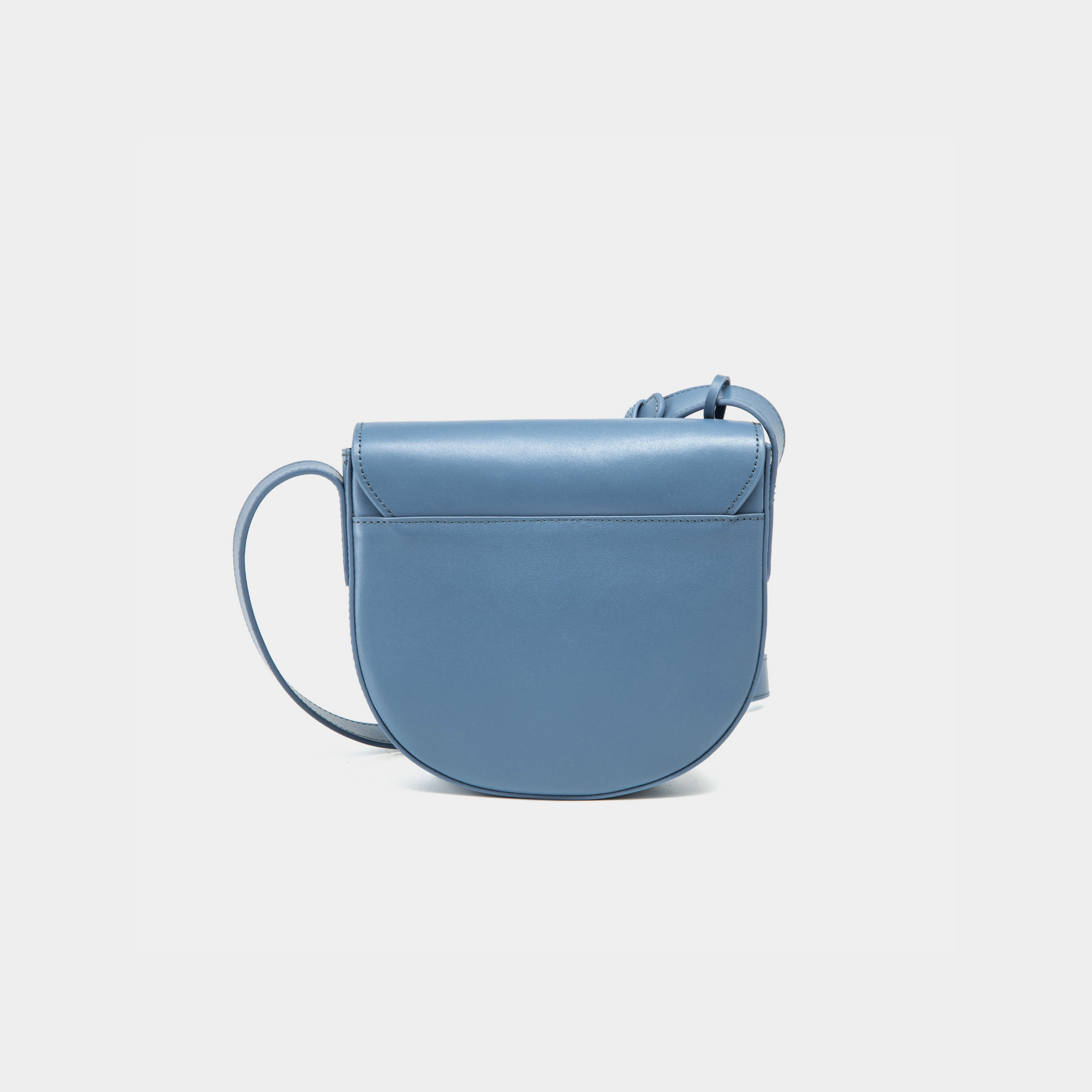 A back view of the half-moon crossbody bag in black leather, showcasing its smooth, rounded structure. The stone blue of the bag features clean, minimalist detailing, highlighting the high-quality craftsmanship. The adjustable strap connects seamlessly to the body of the bag, maintaining its sleek, functional design.