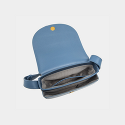 The interior of the stone blue half-moon crossbody bag is revealed, showcasing a smooth flap with a magnetic button closure. The main compartment features an open design, complemented by a neatly stitched inner zip pocket for securing small items. The interior lining has a subtle pattern, adding to the elegance of the bag's craftsmanship.