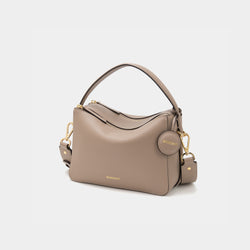 An upgraded double zip leather bag in a sandstone color displayed against a plain background. The bag features a structured design with two visible zip compartments, showcasing its functionality and sleek style. The smooth leather texture and subtle gold-tone zipper accents add a touch of elegance to the minimalist look. The sandstone color, a soft and neutral shade, enhances the bag's versatility, making it suitable for both casual and professional settings.