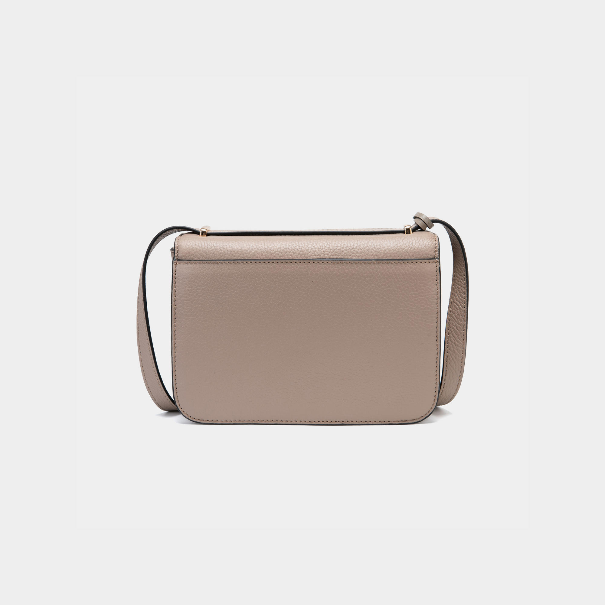 A back view of a structured clay-colored boxy leather bag, showcasing its smooth and minimalistic design. The back panel is free of any additional features or compartments, emphasizing its sleek silhouette. The leather strap is visible, offering an adjustable length for versatile styling. The edges are neatly stitched, adding to the refined craftsmanship of the bag.