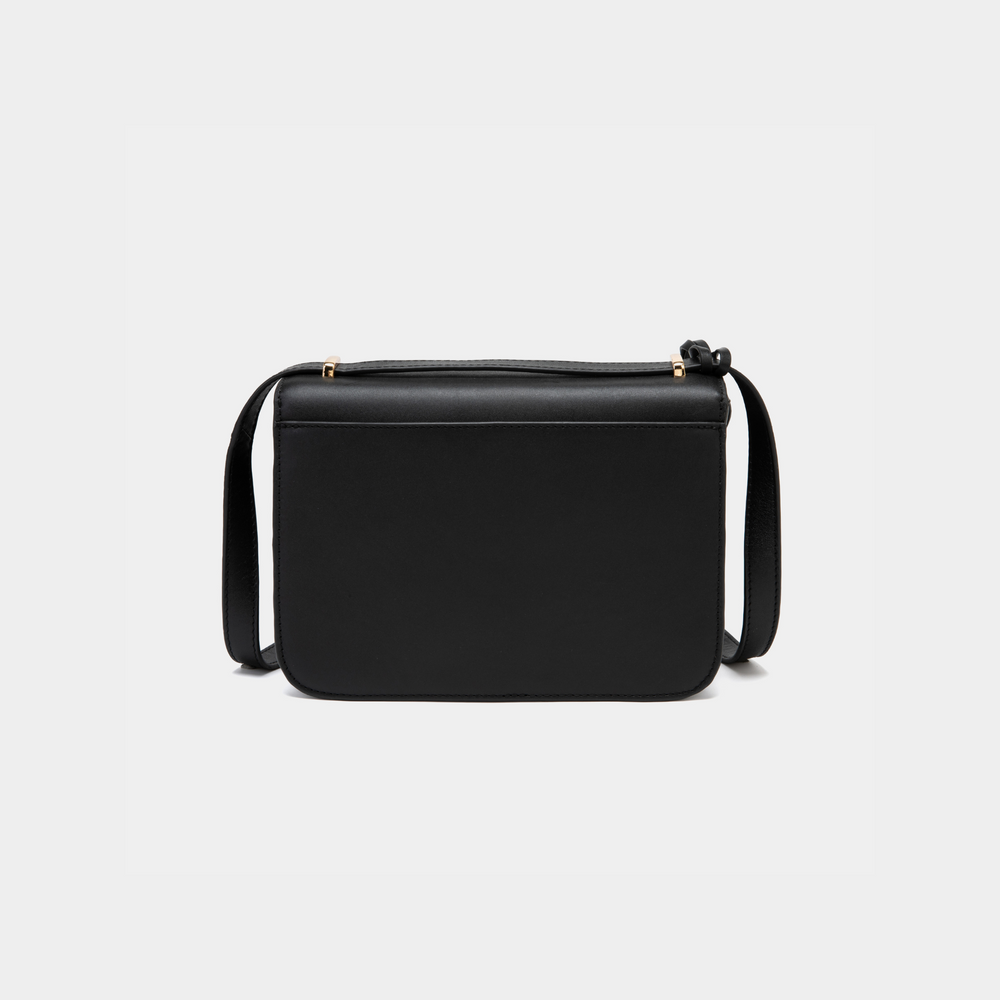 A back view of a structured black-colored boxy leather bag, showcasing its smooth and minimalistic design. The back panel is free of any additional features or compartments, emphasizing its sleek silhouette. The leather strap is visible, offering an adjustable length for versatile styling. The edges are neatly stitched, adding to the refined craftsmanship of the bag.