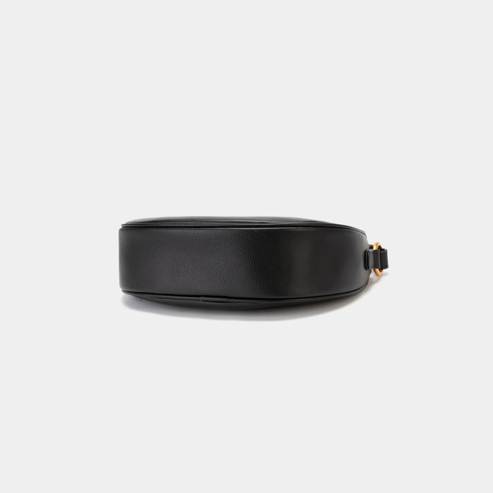 Bottom view of the Crescent Moon bag in black, showcasing the smooth leather base with a minimalistic and sleek finish. The design emphasizes the clean lines and structure of the bag, with subtle stitching details along the edges. The gold hardware complements the elegant black leather, adding a touch of sophistication.