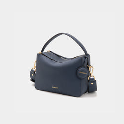 An upgraded double zip leather bag in a marine blue color displayed against a plain background. The bag features a structured design with two visible zip compartments, showcasing its functionality and sleek style. The pebbled leather texture and subtle gold-tone zipper accents add a touch of elegance to the minimalist look. The sandstone color, a soft and neutral shade, enhances the bag's versatility, making it suitable for both casual and professional settings.