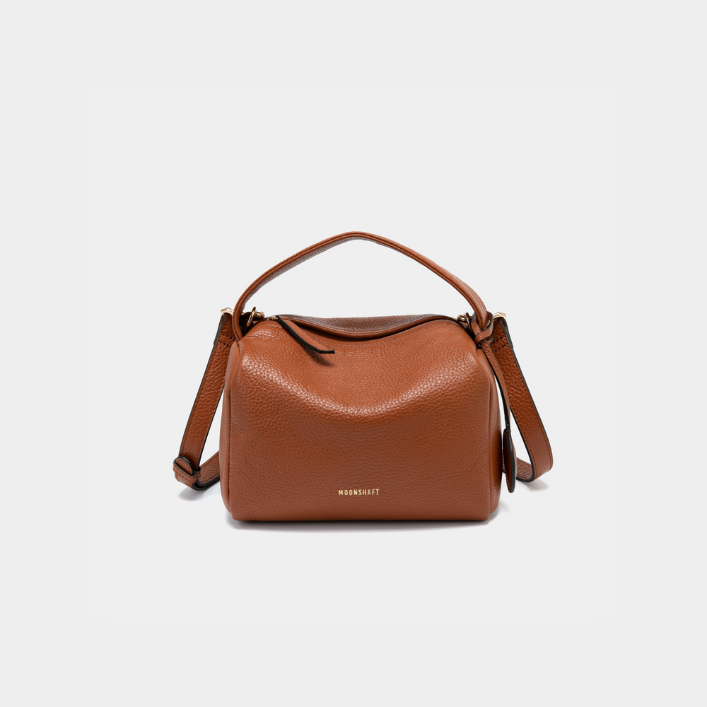 Moonshaft tan Bag in taupe pebbled leather with a boxy, structured design, featuring a top handle and detachable shoulder strap, along with the Moonshaft logo embossed in gold on the front.