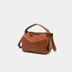 The image shows the Moonshaft Loaf Bag in tan pebbled leather, captured from a front-side angle. The bag's boxy, structured design is highlighted, along with the top handle and detachable shoulder strap draping down the side. The Moonshaft logo is clearly visible on the front.