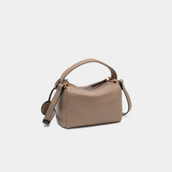 Moonshaft taupe-color Loaf Bag from a back-side angle, focusing on the rear of the bag. The bag's structured design and pebbled leather texture are highlighted, with the handle arcing over the top. The detachable shoulder strap drapes to the side, showcasing the bag's versatile carry options. The smooth zip closure is visible at the top of the bag.