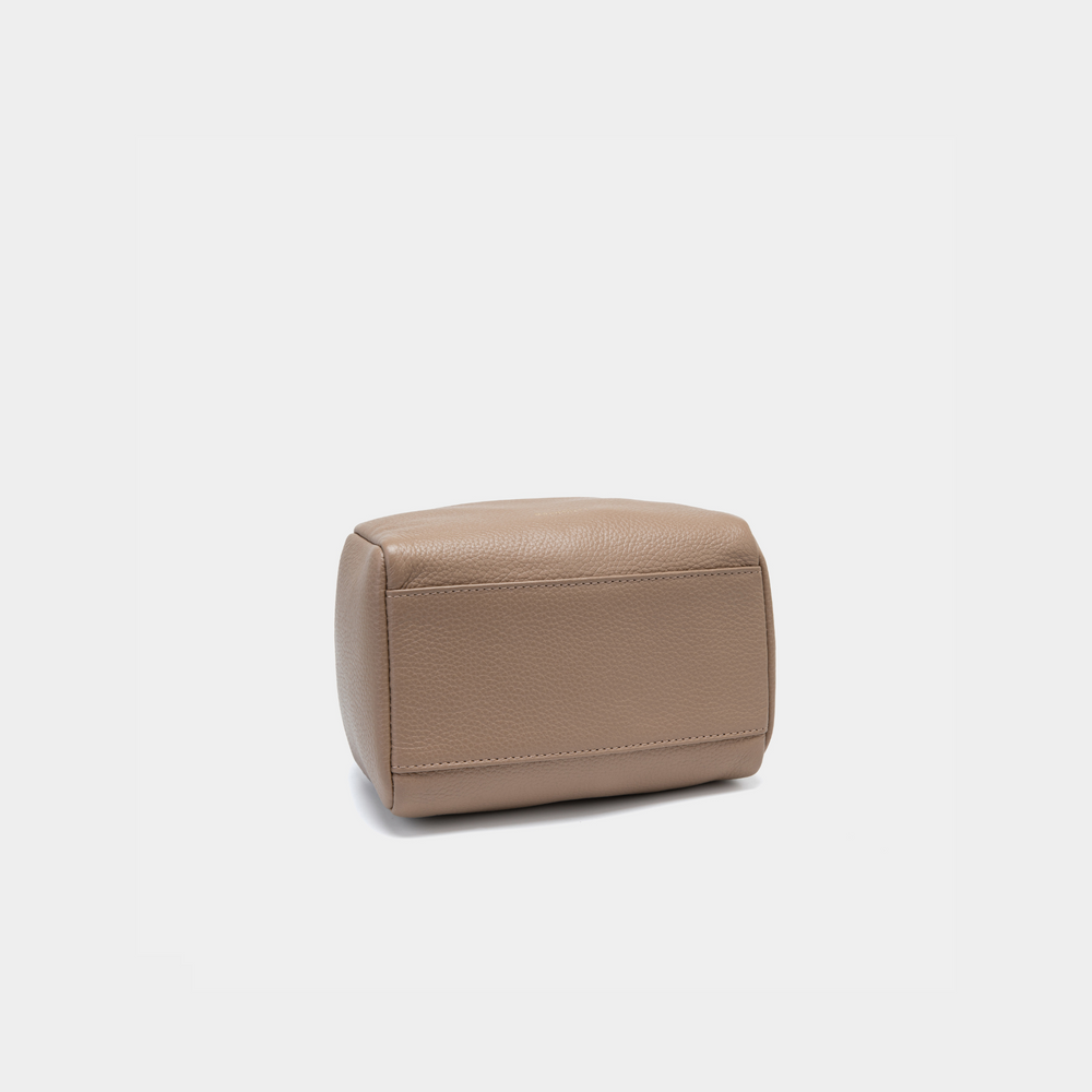 This image showcases the bottom view of the Moonshaft Loaf Bag in taupe color. The base is structured, featuring smooth, pebbled leather with reinforced stitching along the edges for durability. The tan color highlights the texture and craftsmanship of the leather, creating a refined, polished look for this structured bag. The smooth, minimalistic design of the base complements the overall aesthetic of the bag