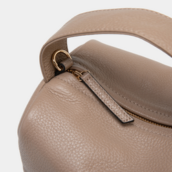 A close-up view of the taupe Loaf Bag's pebbled leather texture, highlighting the gold-tone zipper and hardware. The zipper pull is crafted from matching taupe leather, and the handle is securely attached with gold hardware, emphasizing the bag's premium craftsmanship and attention to detail.