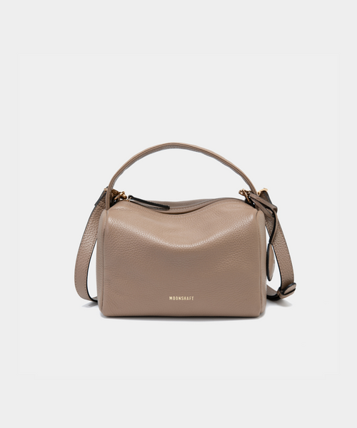 Moonshaft Loaf Bag in taupe pebbled leather with a boxy, structured design, featuring a top handle and detachable shoulder strap, along with the Moonshaft logo embossed in gold on the front.