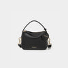 A close-up of the Mini Double Zip Bag in black color, made from pebbled leather. The bag features a top handle and an adjustable shoulder strap with gold-tone hardware. It has two zippered compartments for storage and a round leather tag attached to the side, embossed with the brand logo 'MOONSHAFT' in gold. The minimalist and structured design enhances its modern and stylish appeal.
