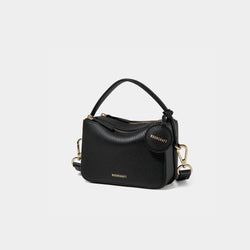 A side-front view of the Mini Double Zip Bag in black color, made from pebbled leather. The bag features a top handle, gold-tone hardware, and an adjustable shoulder strap. It has two zippered compartments and a small round leather tag attached to the side, embossed with the 'MOONSHAFT' logo in gold. The clean and structured design showcases its minimalist elegance and functional style.