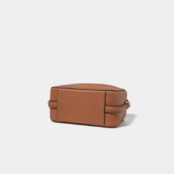 A bottom view of the Mini Double Zip Bag in toffee color, showcasing its structured base made from pebbled leather. The clean, minimalist design emphasizes the bag’s sturdy construction, with subtle stitching and smooth edges, enhancing its overall durability and style.