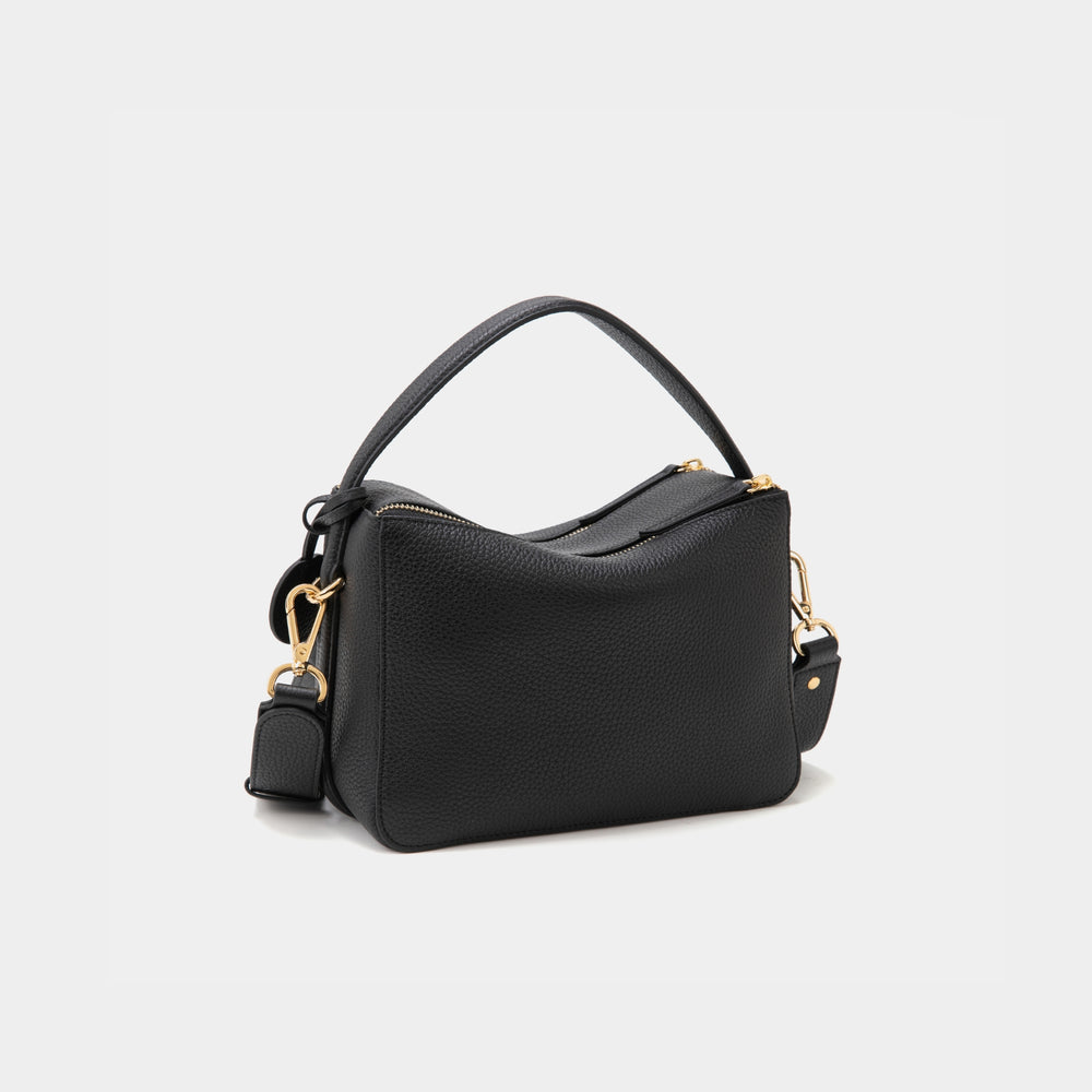 A back view of the upgraded double zip pebbled leather bag in black, displayed against a white background. The bag features a structured design with gold-tone zippers and hardware, including a detachable strap attached by a gold clasp. The smooth, pebbled leather texture is highlighted, along with the clean lines and minimalistic silhouette. The top handle adds versatility to the design, making the bag both chic and functional for various occasions.