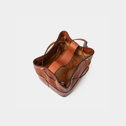 Top view of the tan-colored pebbled leather bucket bag, showing the spacious interior with a soft lining and an inner zip pocket for secure storage. The drawstring opening adds both style and functionality to the design.
