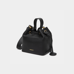 Angled view of a black-colored pebbled leather bucket bag with gold-tone accents, featuring a drawstring closure and a sturdy top handle. The MOONSHAFT logo is embossed in gold on the front, with a small circular leather charm attached to the side for added elegance.