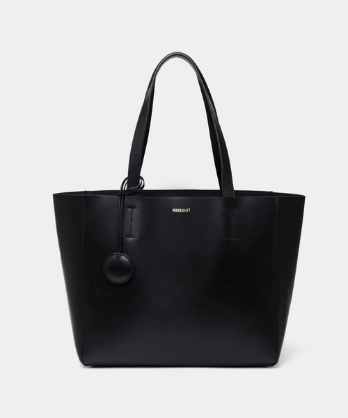 A black leather tote bag displayed from the front, highlighting its minimalist and structured design. The bag features a smooth leather texture with no external pockets or embellishments, emphasizing its sleek and elegant appearance. Two sturdy leather handles are visible, and the black color enhances its versatility, making it a stylish accessory for various outfits and occasions. The clean lines and spacious design offer practicality, making this tote suitable for everyday use.